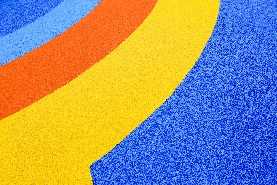 a blue yellow and red carpet with a curved design tMcg1qrz2Hc jpg