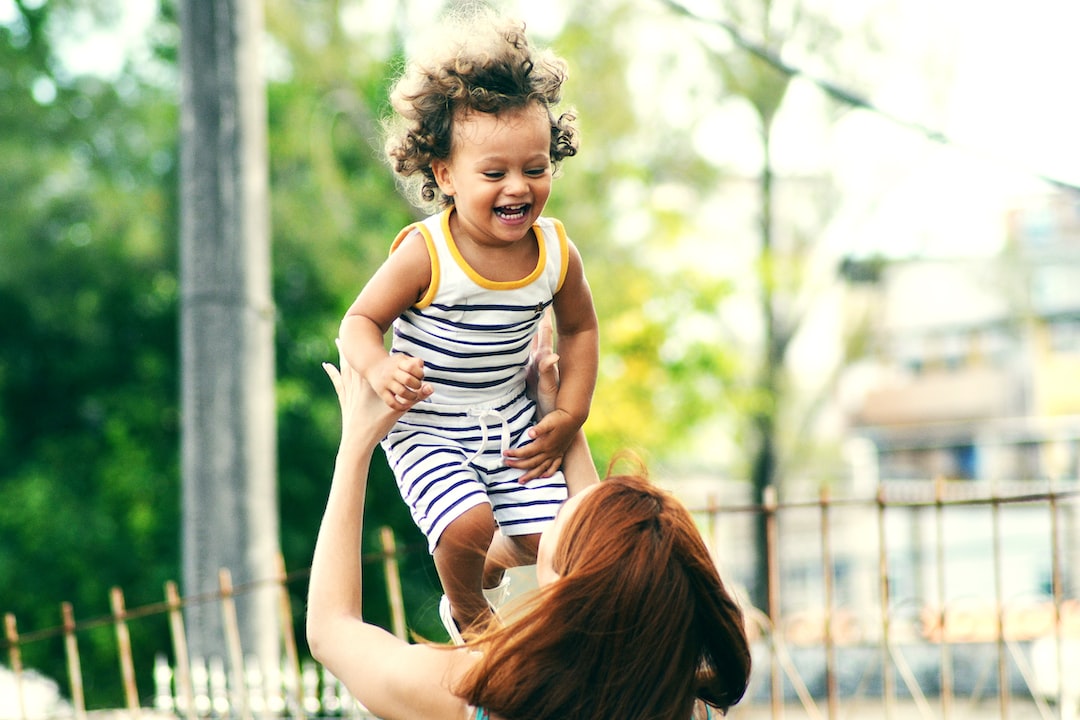 selective focus photo of woman lifting child during daytime Wr3HGvx RSM jpg