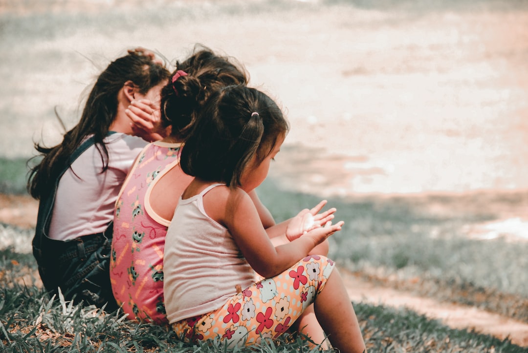 three children sitting on grass Ux5mdMJNEA jpg