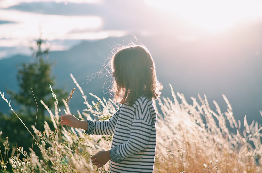 woman in black and white striped long sleeve shirt standing on brown grass field during daytime oBuJHbAe6yE jpg